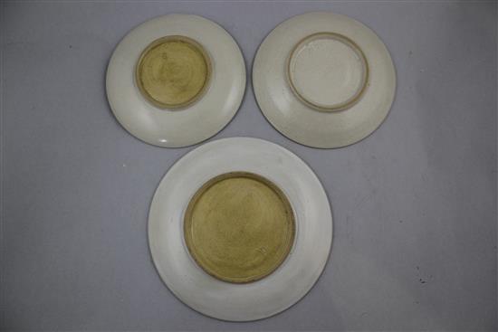 Dame Lucie Rie. A mustard glazed pottery plate and two matching saucers, 18.2cm and 15.2cm